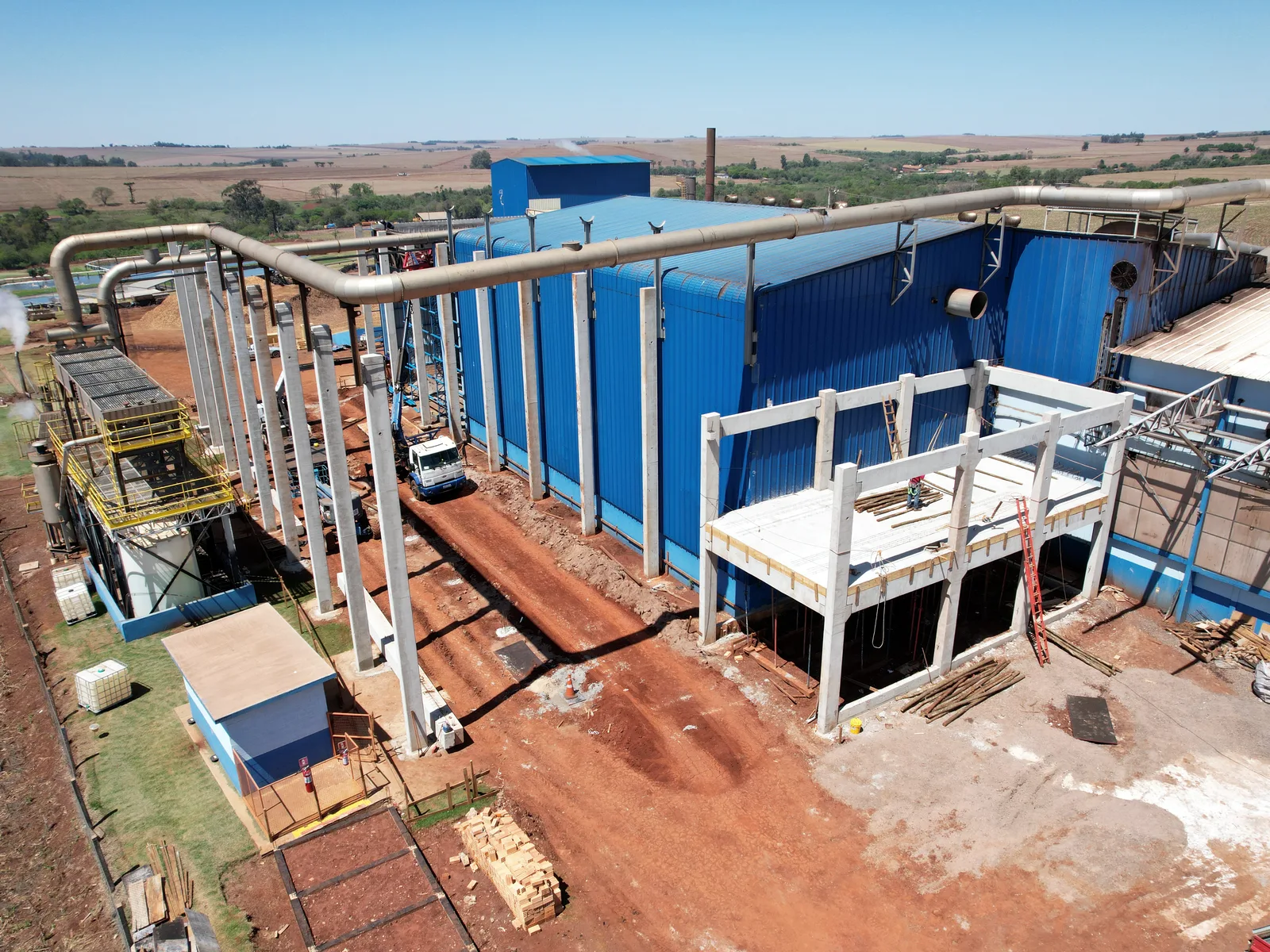 Vista aérea de ampliação industrial com estrutura pré-moldada em montagem
