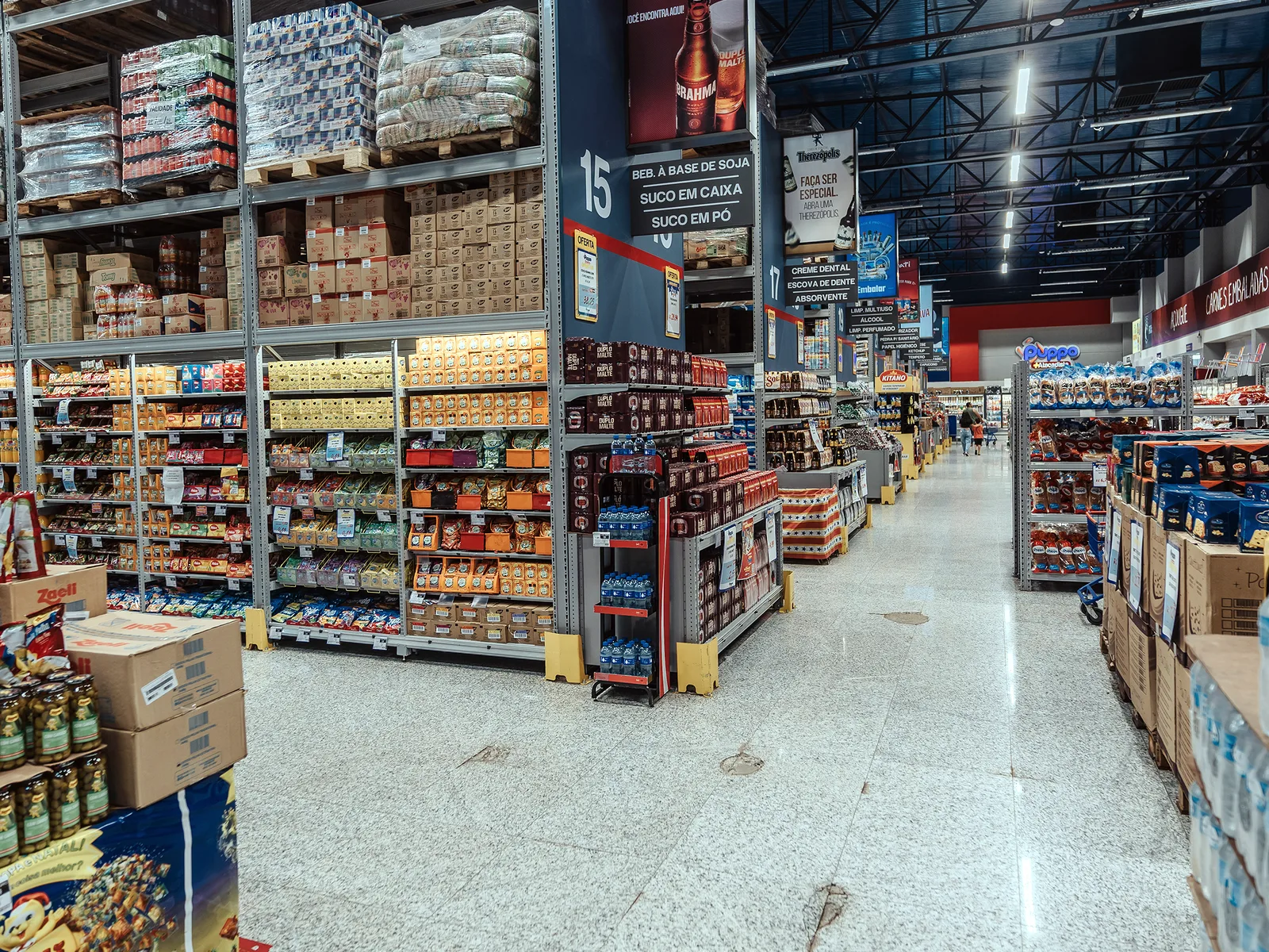Salão de vendas de loja de atacado com estrutura metálica aparente na cobertura
